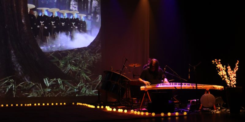 imagem da apresentação do filme Sonhos projeto na tela do teatro do Sesc Bom Retiro com participação dos músicos no palco