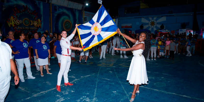 Casal de Mestre sala e Porta-bandeira apresentando a bandeira da escola de samba Acadêmicos do Tucuruvi